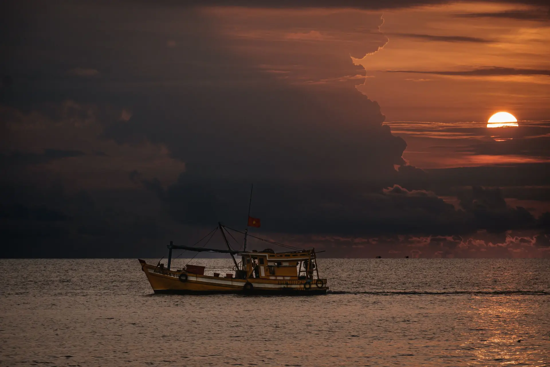 A fishing boat sails on the sea at sunset, captured in Phu Quoc, Vietnam.