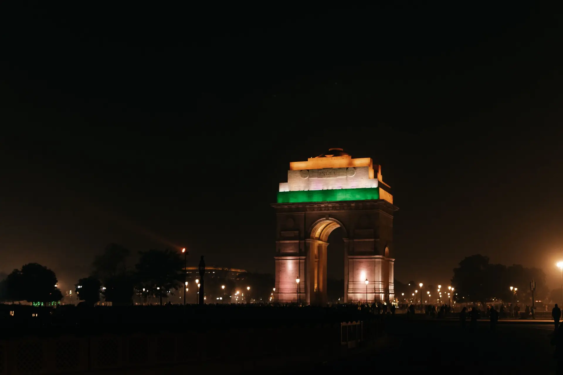 India Gate, New Delhi, beautifully illuminated at night, showcasing vibrant colors and architectural beauty.