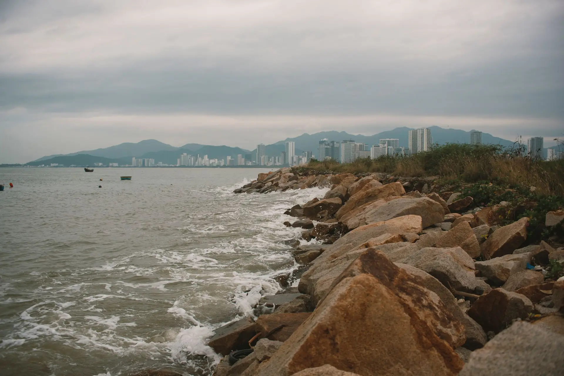 Dramatic coastal cityscape featuring rocky shoreline in Nha Trang, Vietnam.